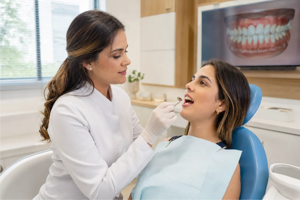 Dentista avaliando a mordida de uma paciente para indicar tratamento ortodôntico em Perdizes.