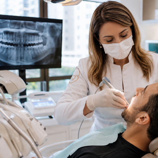 Dentista realizando laserterapia após extração de siso para reduzir a dor, controlar a inflamação e acelerar a cicatrização na Rodrighero Odontologia.